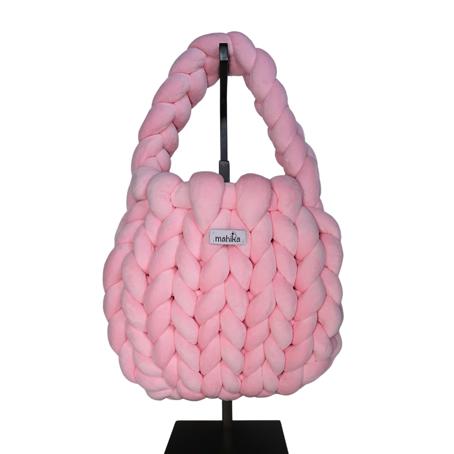Pink braided and finger knitted handbag on a stand with 'mahalo' label against a white background