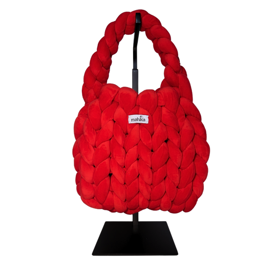 bright Red woven and finger crocheted handbag on a black stand with 'Malika' branding.